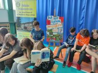 Uczniowie i pani dyrektor czytają książki